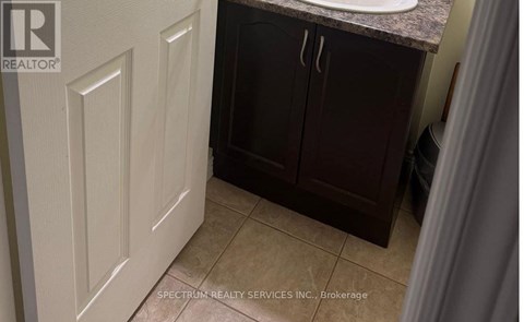 A bathroom with a white door and brown cabinets.