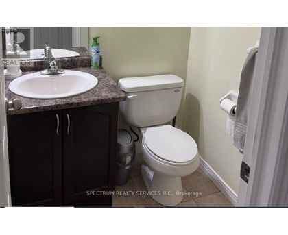 A white toilet sits next to a sink in a bathroom.