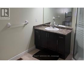 A bathroom with a sink, mirror, and cabinets.