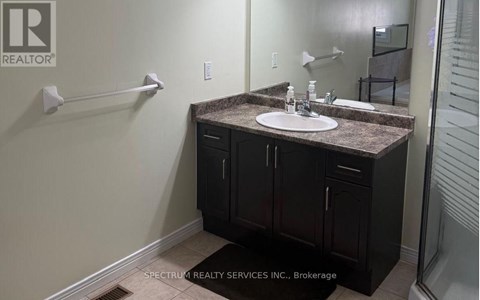 A bathroom with a sink, mirror, and cabinets.