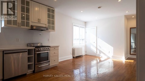 A kitchen with wooden floors and a stainless steel dishwasher.