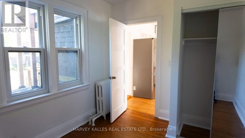 A real estate listing photo of a small, empty room with a doorway leading to another room.