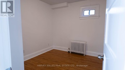 A room with a window and a radiator on the floor.