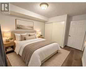 A bedroom with a large bed and a painting on the wall.