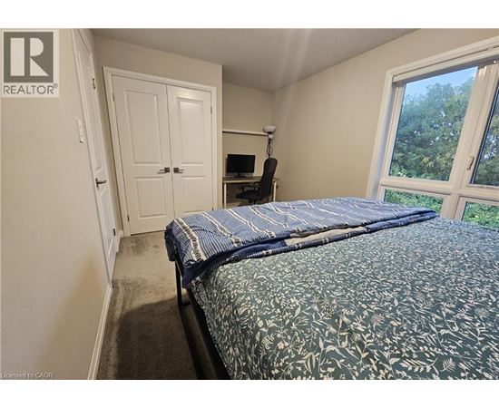 A bedroom with a bed, a chair, and a window.