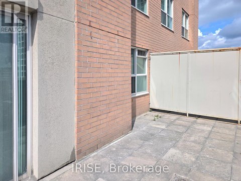 A red brick building with a white fence in front.