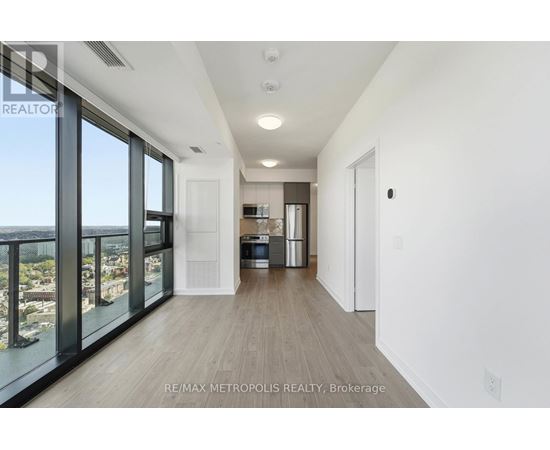 A spacious, empty room with a view of the cityscape outside the large windows.