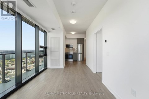 A spacious, empty room with a view of the cityscape outside the large windows.