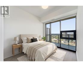A bedroom with a large bed and a view of the city.