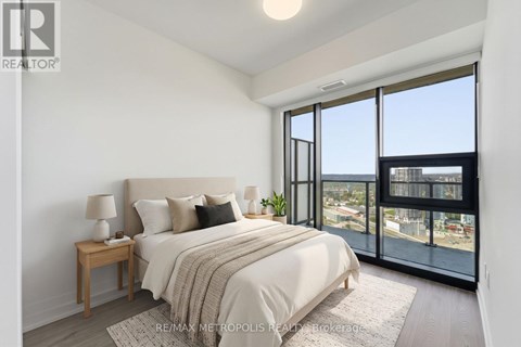 A bedroom with a large bed and a view of the city.