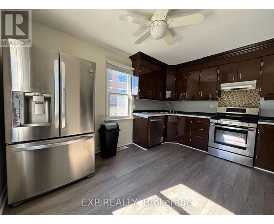 A kitchen with a stainless steel refrigerator and wooden cabinets.