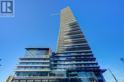 A tall building with a unique triangular top is the focal point of the image.