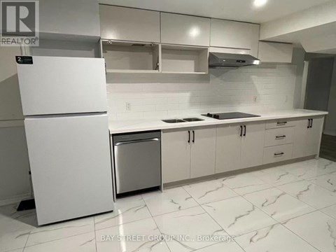 A white fridge and dishwasher in a kitchen with white cabinets.