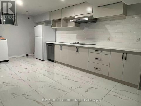 A kitchen with white cabinets and a white fridge.