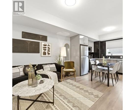 A modern living room with a black sofa, a coffee table, and a dining area with a table and chairs.