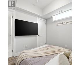 A bedroom with a bed covered in a white blanket and a blackboard on the wall.