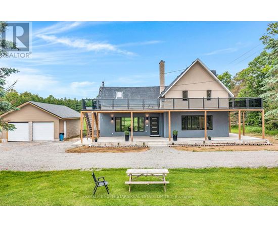A modern house with a large front yard and a picnic table.