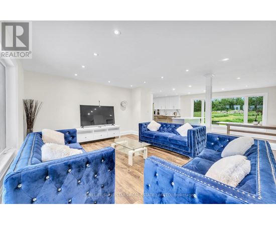 A living room with blue velvet sofas and a television.