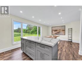 A kitchen with a large island and wooden floors.