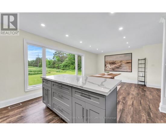 A kitchen with a large island and wooden floors.