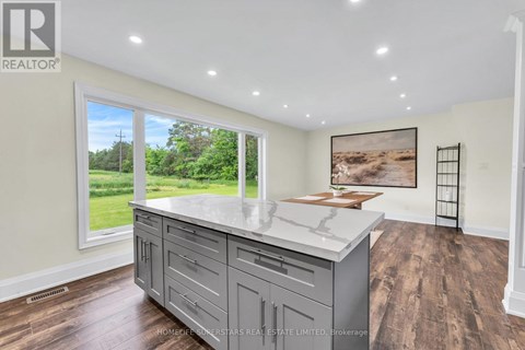 A kitchen with a large island and wooden floors.