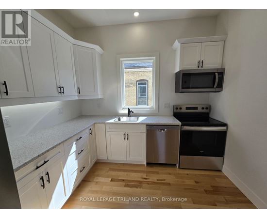 A kitchen with white cabinets and a window.