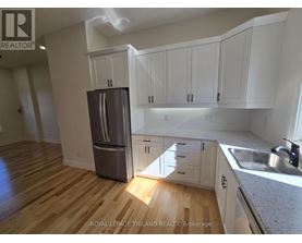 A kitchen with white cabinets and a wooden floor.