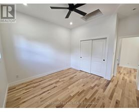 A room with wooden flooring and a ceiling fan.