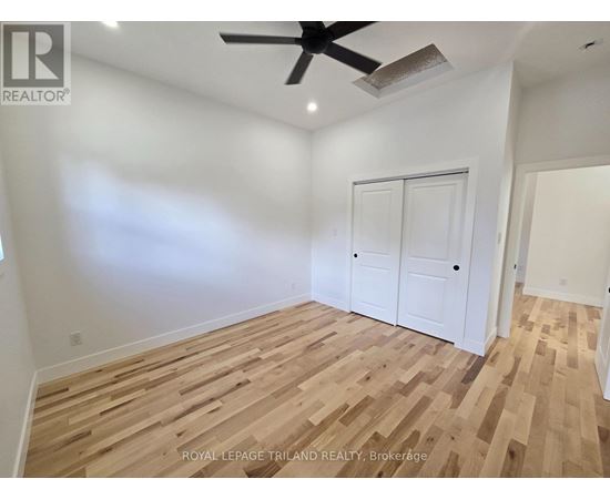A room with wooden flooring and a ceiling fan.