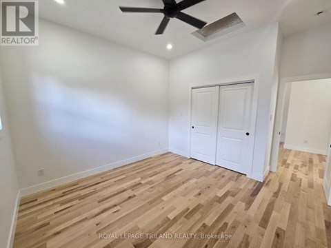 A room with wooden flooring and a ceiling fan.