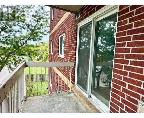 A red brick house with a balcony and glass door.