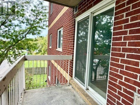 A red brick house with a balcony and glass door.