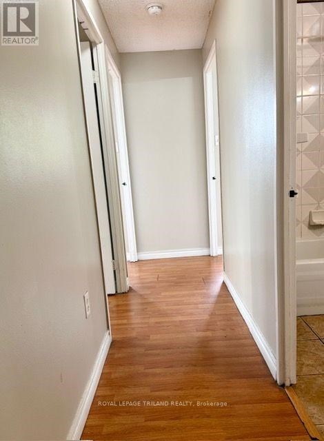 A hallway with wood floors and white walls.