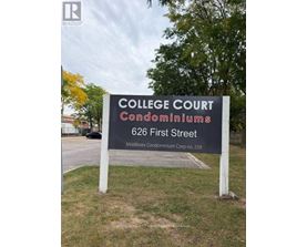 A sign for College Court Condominiums stands in a grassy area.