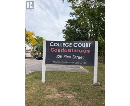A sign for College Court Condominiums stands in a grassy area.
