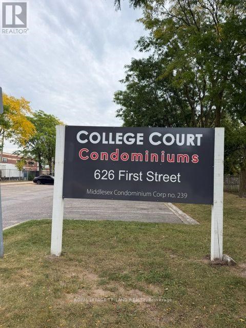 A sign for College Court Condominiums stands in a grassy area.