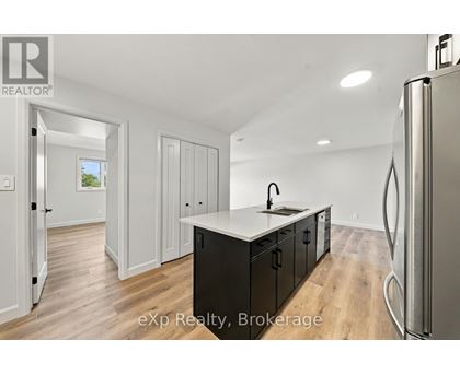 A kitchen with a refrigerator on the right side.