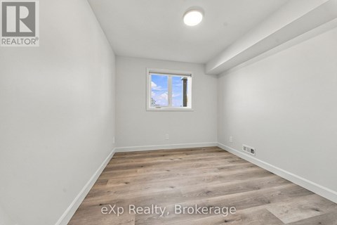 A room with a window and wooden flooring.