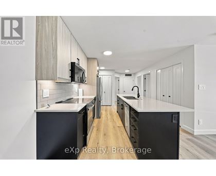 A modern kitchen with wooden cabinets and black appliances.