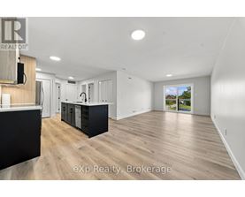 A spacious room with wooden flooring and white walls.
