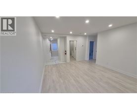 A room with a white wall and wooden flooring.