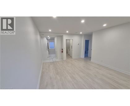 A room with a white wall and wooden flooring.