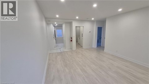 A room with a white wall and wooden flooring.
