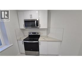 A kitchen with white cabinets and a black stove top oven.