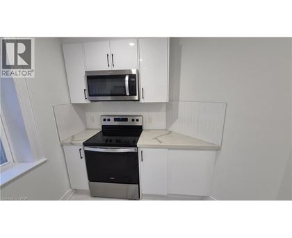 A kitchen with white cabinets and a black stove top oven.