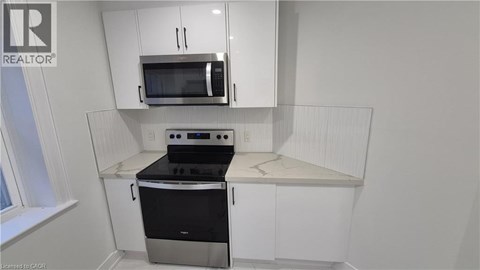 A kitchen with white cabinets and a black stove top oven.