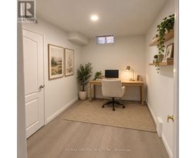 A home office with a desk, chair, and a potted plant.