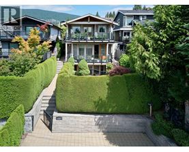 A house with a green lawn and a black gate.