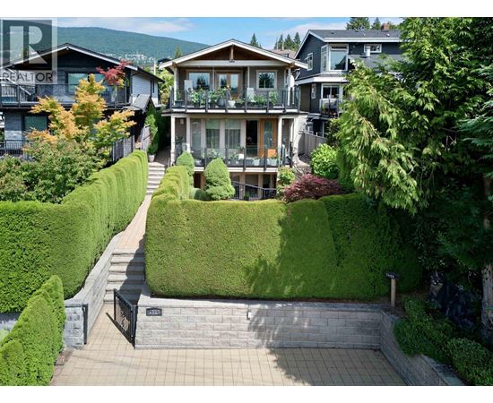 A house with a green lawn and a black gate.