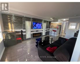 A living room with a stone fireplace and a flat screen TV mounted above it.